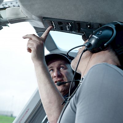 Ein Mann zeigt einem anderen etwas im Hubschrauber